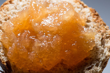 Fototapeta premium Apple jam with bubbles layered on toasted bread close up