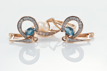 Gold earrings in the shape of a horseshoe adorned with Topaz stones and ring with pearl