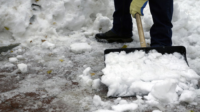 man cleans snow from the yard