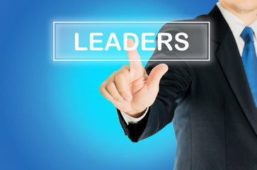 Business man is pushing LEADERS transparent button word over blue gradient background, business concept