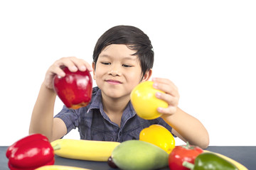 Fototapeta na wymiar Asian healthy boy showing happy expression with variety colorful fruit and vegetable over white background