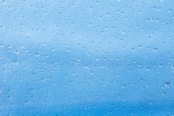 Obraz premium Rain drop on at glass window over blue sky background