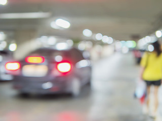 Fototapeta premium Niewyraźne zdjęcie kobiety idzie niebezpiecznie na parkingu samochodowym