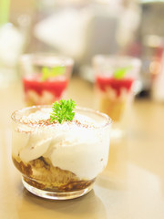 Small banoffee cup with blurred of other desserts background