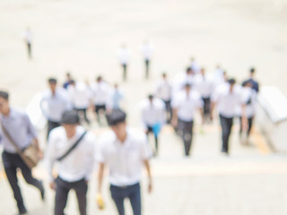 Blurred photo of crowded people is walking upstair