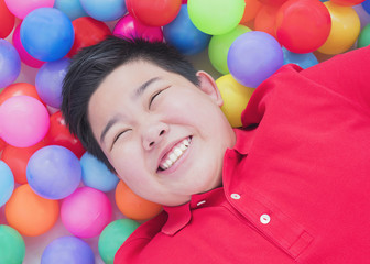 Fototapeta na wymiar Happy Asian kid with colorful toy balls