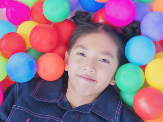 Fototapeta na wymiar Happy Asian kid with colorful toy balls