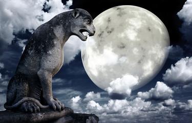 Ancient lion statue and bright moon in the night sky