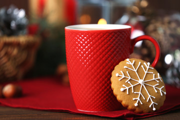 Cup of hot drink and Christmas cookie on table