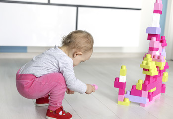 Preschooler child playing with colorful toy blocks
