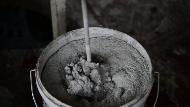 The mixer stirs plaster in bucket