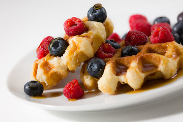 Close-up of waffles with berries and maple syrup