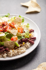 Taco Salad stacked on a bed of brown rice angled view