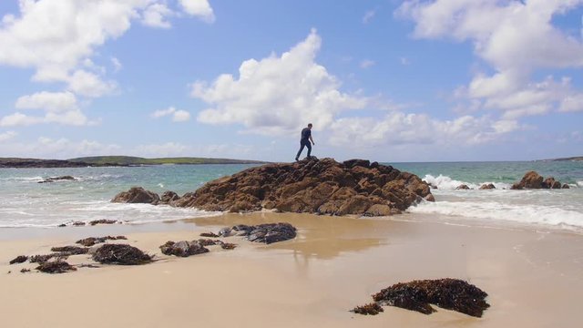 Man Standing on Rocks on the Shore