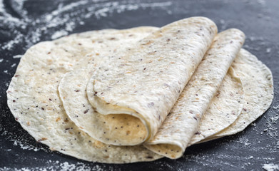 Stack of tortillas on a black surface