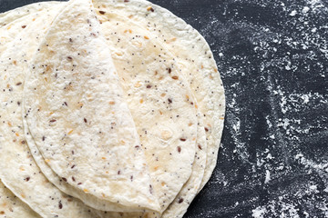 Stack of tortillas on a black surface