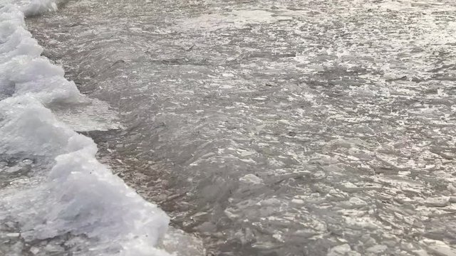 Ice in waves near frozen bank.