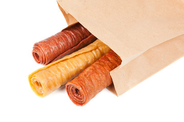 Candied fruit twisted in roll in paper bag isolated on white background. Homemade sweetness of...