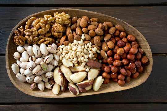 different knds of nuts in a wooden plate