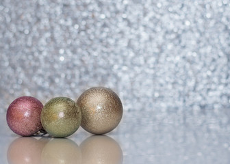 Three different colored Christmas ball on the background bokeh.
