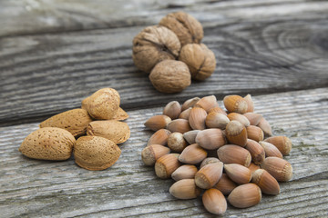 Several mixed nuts in shells  on a old wooden table.