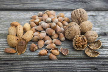 Several mixed nuts in shells  on a old wooden table.