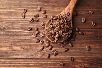 Wooden spoon and coffee beans on wooden background