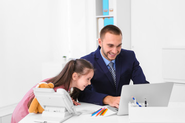 Daughter helping father working in office