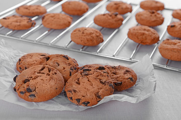 Freshly baked cookies on baking paper and tray rack