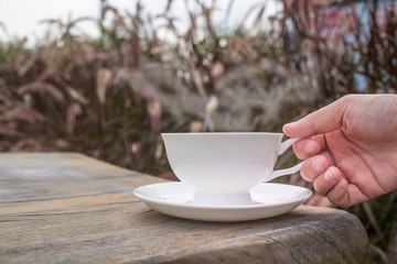 Coffee cup and tea On a Wooden table in the lawn garden.The visual style is warm Feeling relaxed