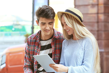 Young couple looking at tablet screen outdoors
