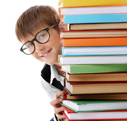 Cute schoolboy and heap of books on white background, closeup