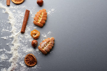 Composition of cookies, flour and natural Christmas decor on grey table