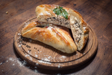traditional georgian baked food kubdari on wooden table;