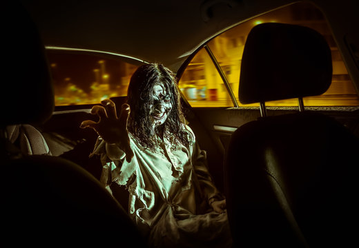 Horror zombie woman with bloody face in the car
