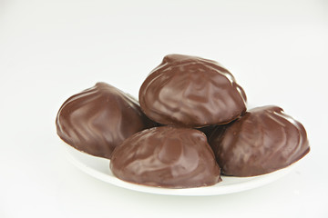 Delicious chocolate marshmallow on plate on white
