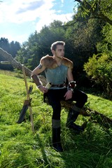 Junger Mittelalterlich gekleidender Mann, hält Trinkhorn hoch in der Hand,  schaut zur Seite und ...