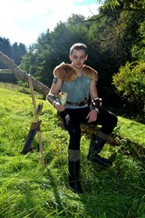 Junger Mittelalterlich gekleidender Mann, hält Trinkhorn hoch in der Hand,  schaut nach unten und ...