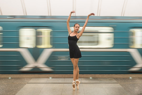 Ballerina in subway with moving train on the background