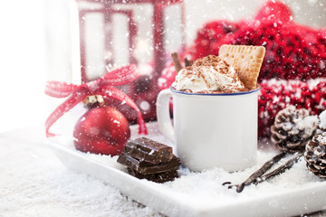Homemade christmas hot chocolate with whipped cream, cacao and cinnamon on a plate on christmas...