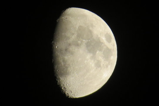 Partial gibbous moon with visible craters in a dark night.