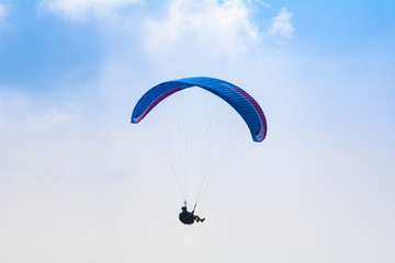Paraglider flying high in the sky