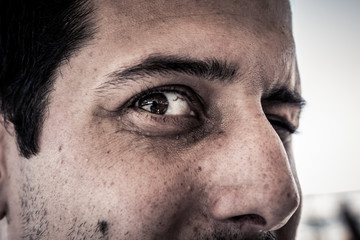 Closeup on face of scary creepy spooky man with evil eyes looking at camera