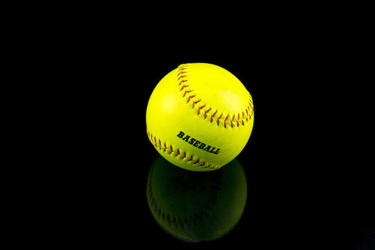 Baseball yellow on a black background .