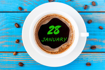 January 28th. Day 28 of month, Calendar on cup morning coffee, blogger workplace background. Winter at work concept. Empty space for text