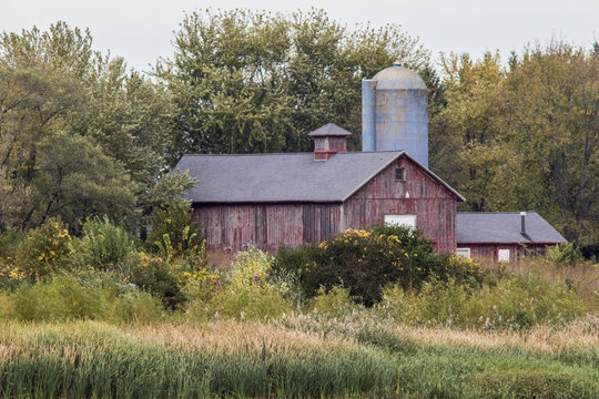 old red barn with blue silo