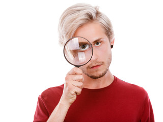 man holds on eye magnifying glass looking through loupe