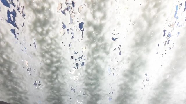foam is running down the front window of a car in the car wash
