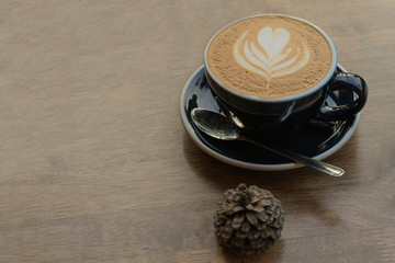 hot fresh coffee in white glass with tree shape of heart foam on wooden table at sunset at coffee time / hot fresh coffee