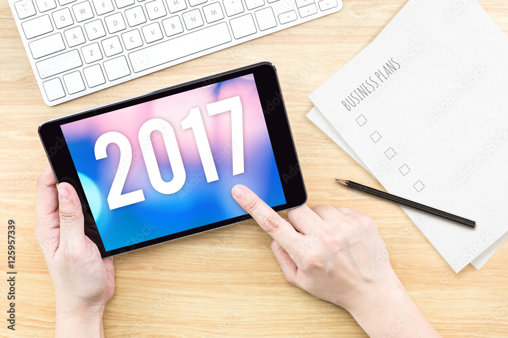 Poster hand touch tablet with 2017 year number on screen with business